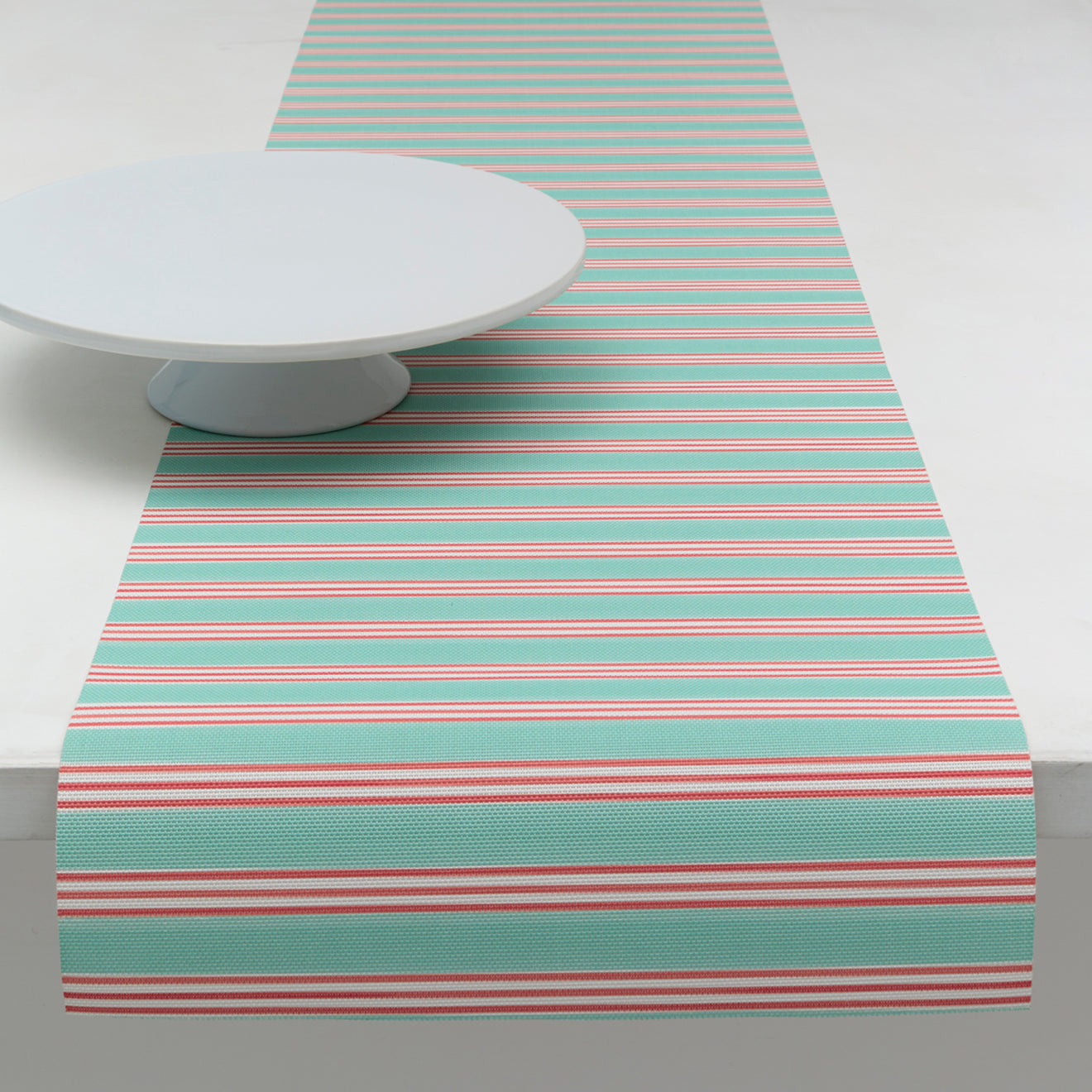 Chilewich striped woven mat with textured terrastrand yarn surface, featuring modern linear design and durable finish.