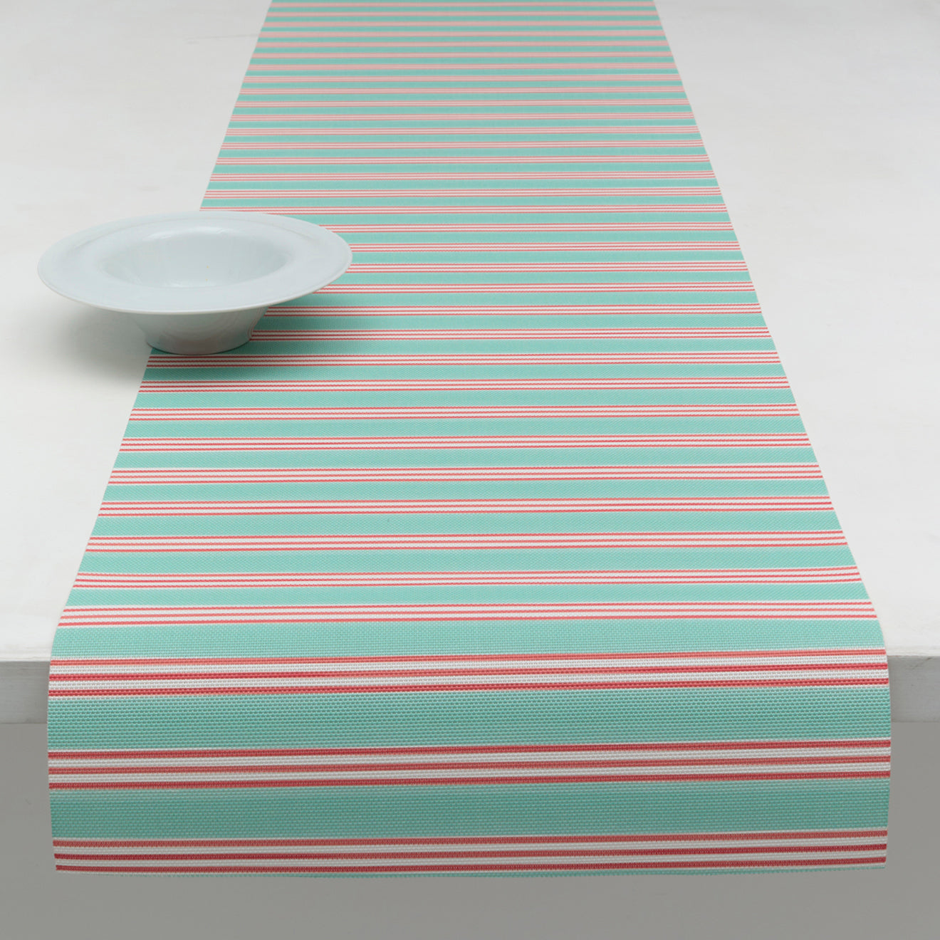 Chilewich striped woven mat with textured terrastrand yarn surface, featuring modern linear design and durable finish.