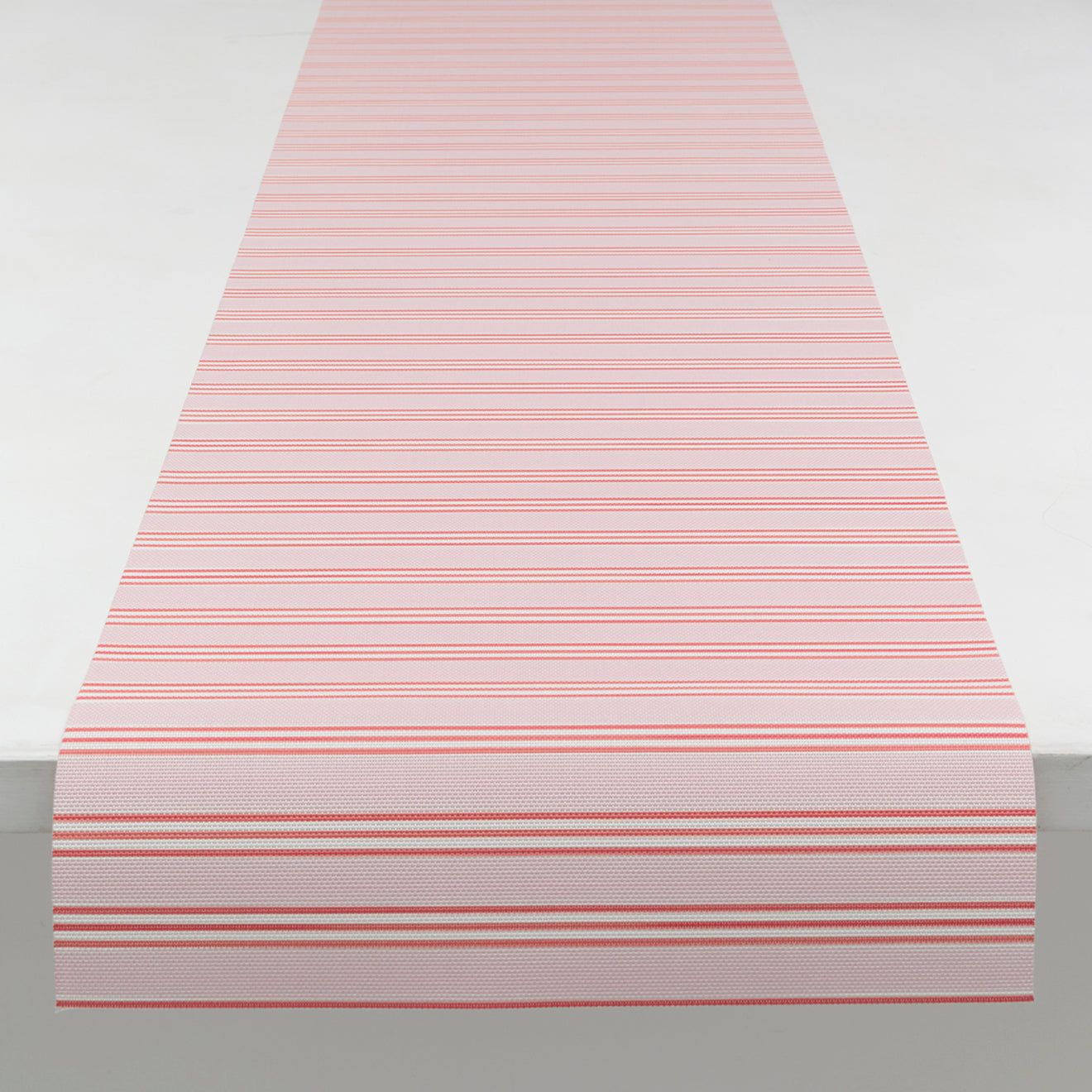 Chilewich striped woven mat with textured terrastrand yarn surface, featuring modern linear design and durable finish.