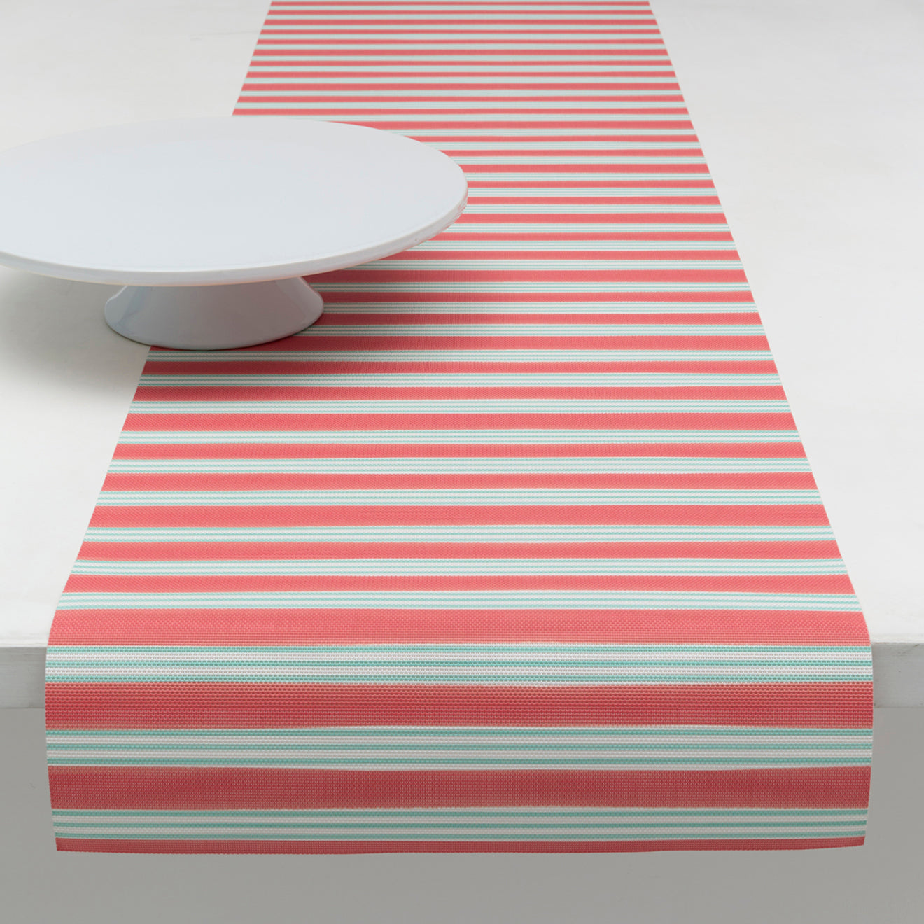Chilewich striped woven mat with textured terrastrand yarn surface, featuring modern linear design and durable finish.