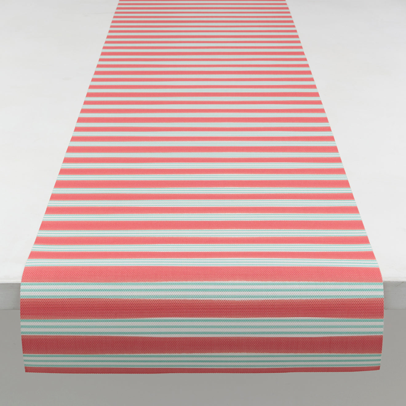 Chilewich striped woven mat with textured terrastrand yarn surface, featuring modern linear design and durable finish.