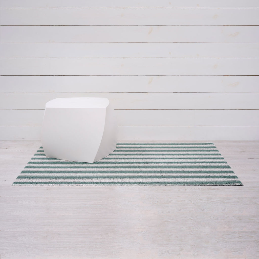 Chilewich striped woven mat with textured terrastrand yarn surface, featuring modern linear design and durable finish.