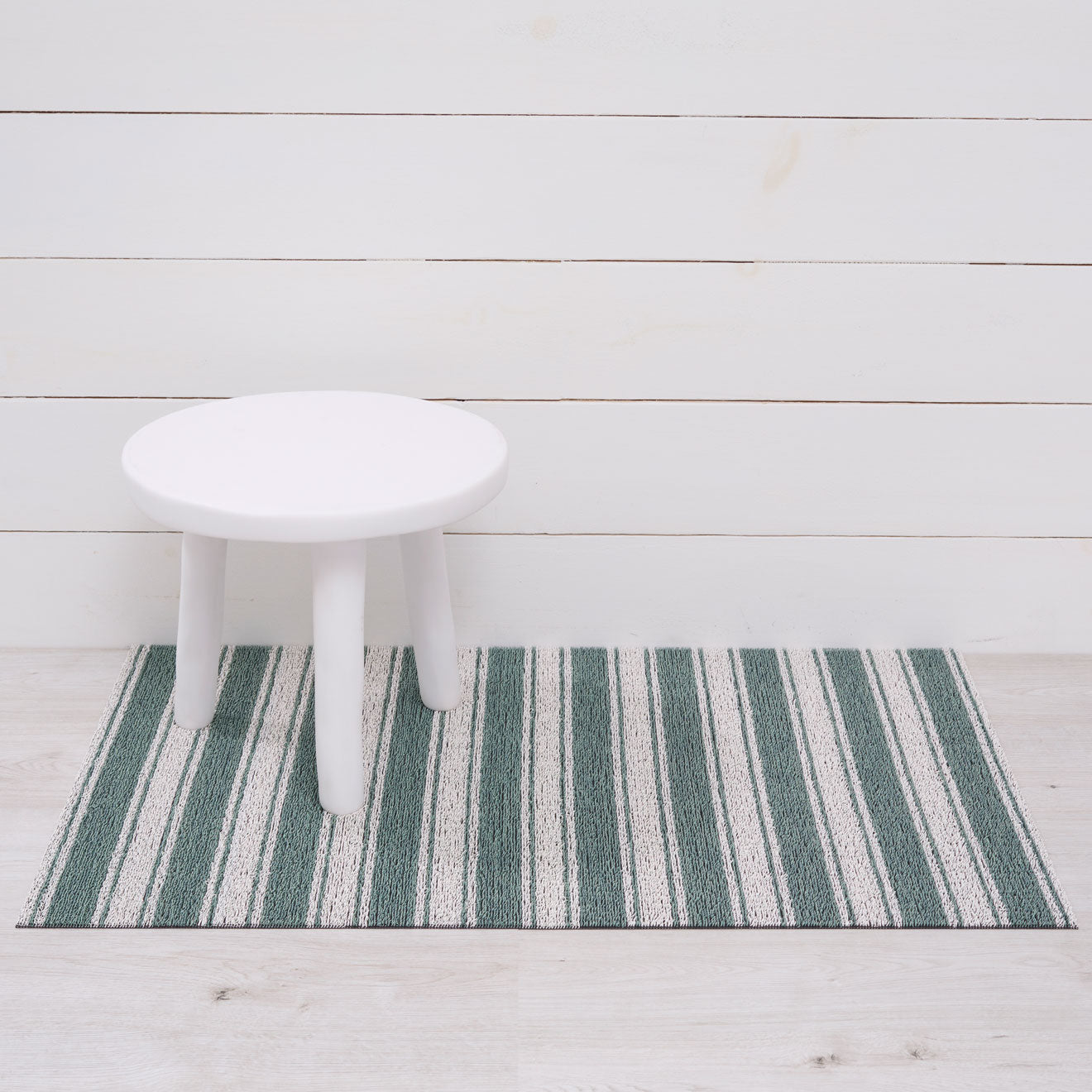 Chilewich striped woven mat with textured terrastrand yarn surface, featuring modern linear design and durable finish.