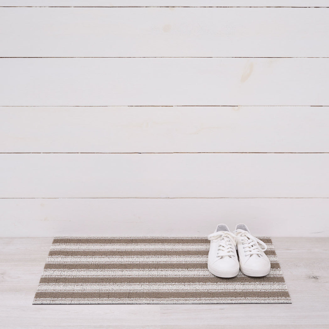 Chilewich striped woven mat with textured terrastrand yarn surface, featuring modern linear design and durable finish.