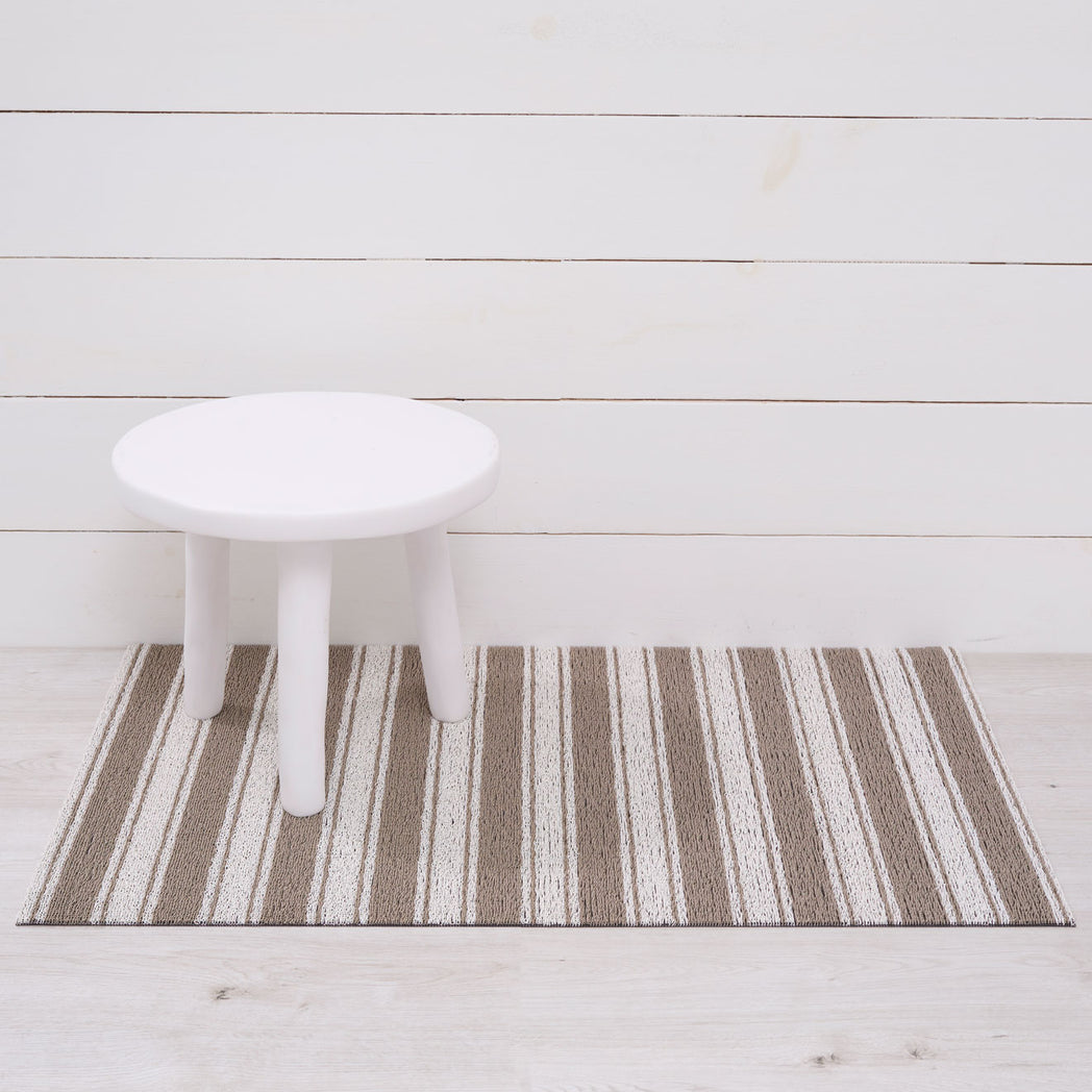 Chilewich striped woven mat with textured terrastrand yarn surface, featuring modern linear design and durable finish.