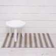 Chilewich striped woven mat with textured terrastrand yarn surface, featuring modern linear design and durable finish.