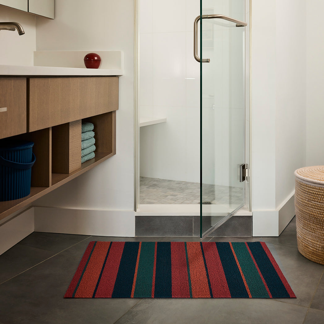 Chilewich striped woven mat with textured terrastrand yarn surface, featuring modern linear design and durable finish.