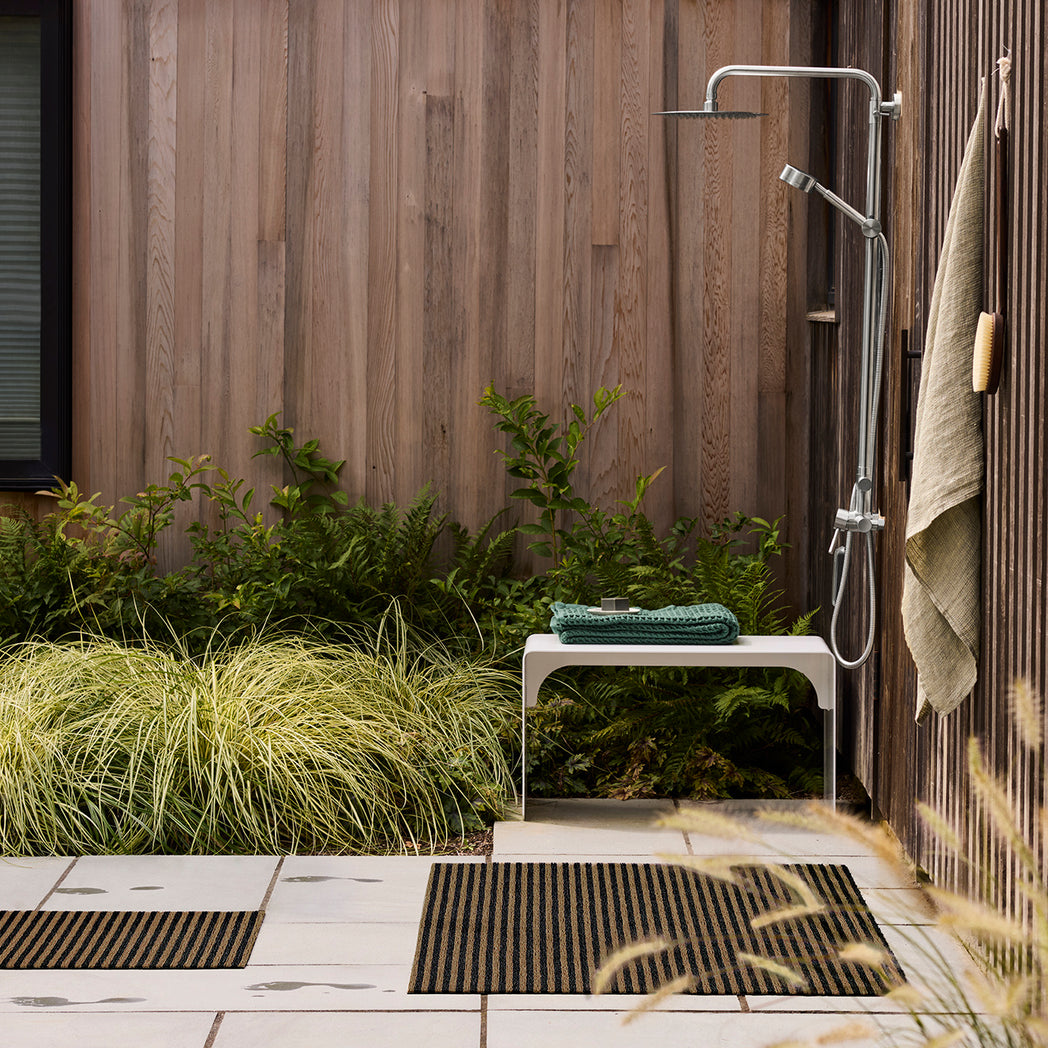 Chilewich striped woven mat with textured terrastrand yarn surface, featuring modern linear design and durable finish.