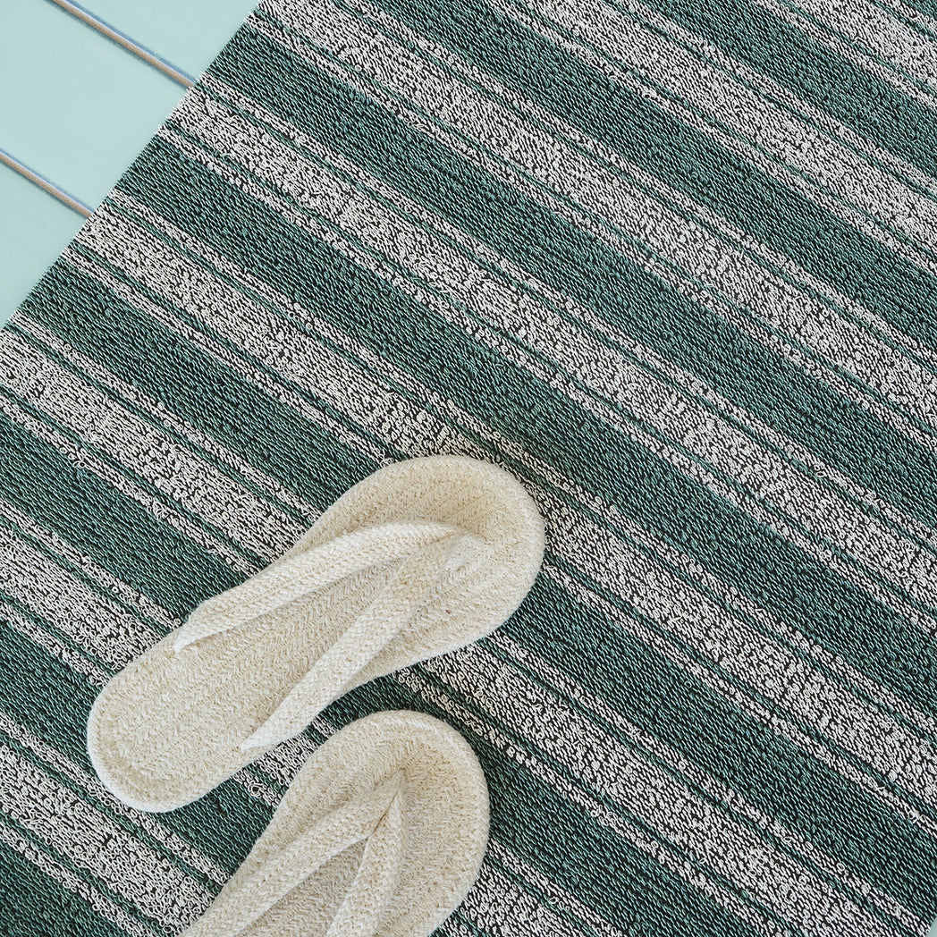 Chilewich striped woven mat with textured terrastrand yarn surface, featuring modern linear design and durable finish.