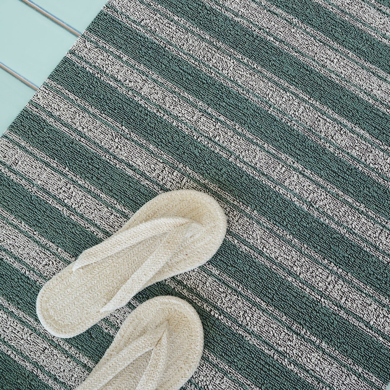 Chilewich striped woven mat with textured terrastrand yarn surface, featuring modern linear design and durable finish.