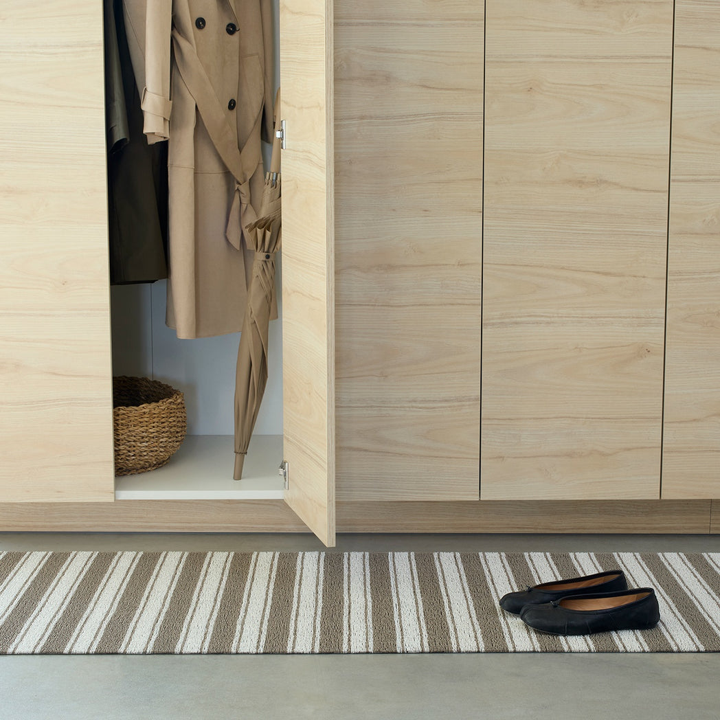 Chilewich striped woven mat with textured terrastrand yarn surface, featuring modern linear design and durable finish.