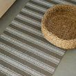 Chilewich striped woven mat with textured terrastrand yarn surface, featuring modern linear design and durable finish.