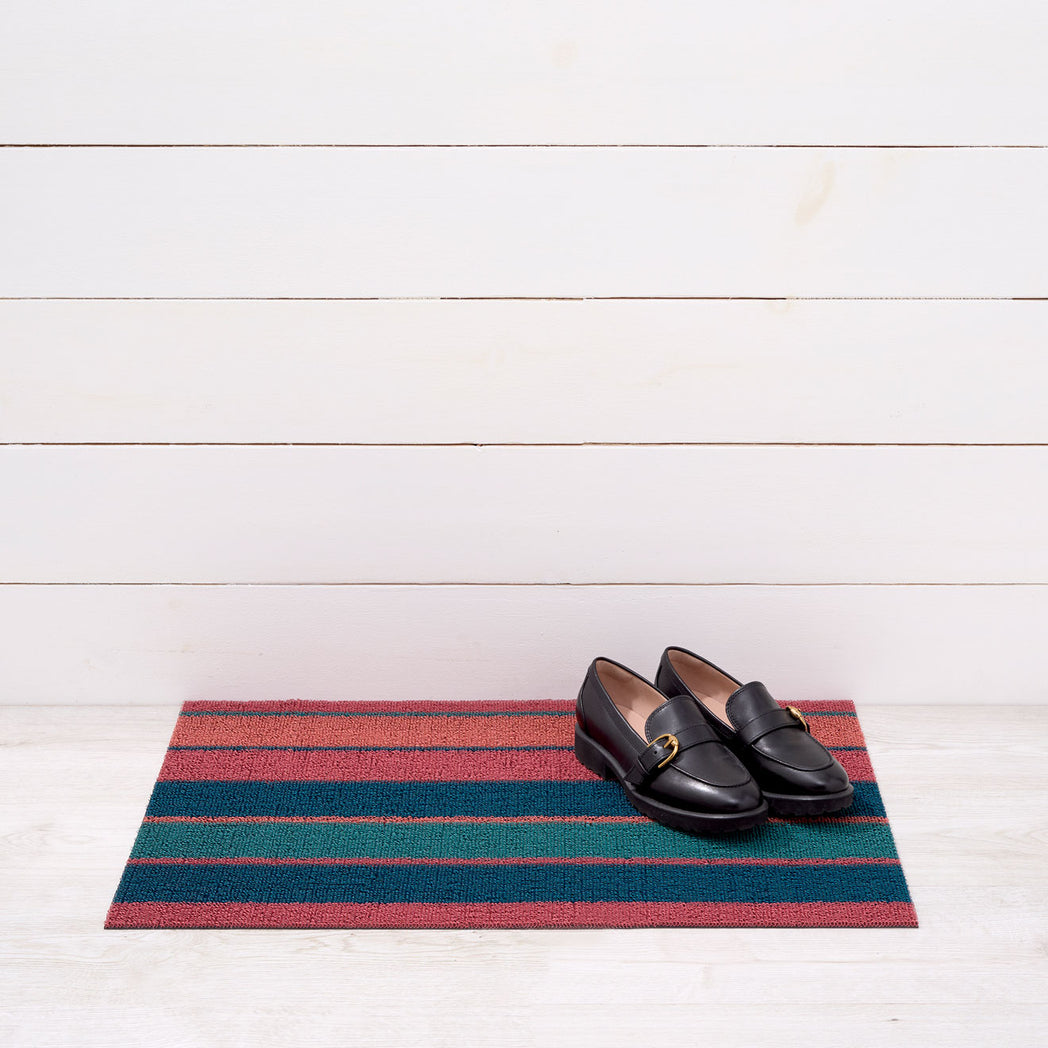 Chilewich striped woven mat with textured terrastrand yarn surface, featuring modern linear design and durable finish.