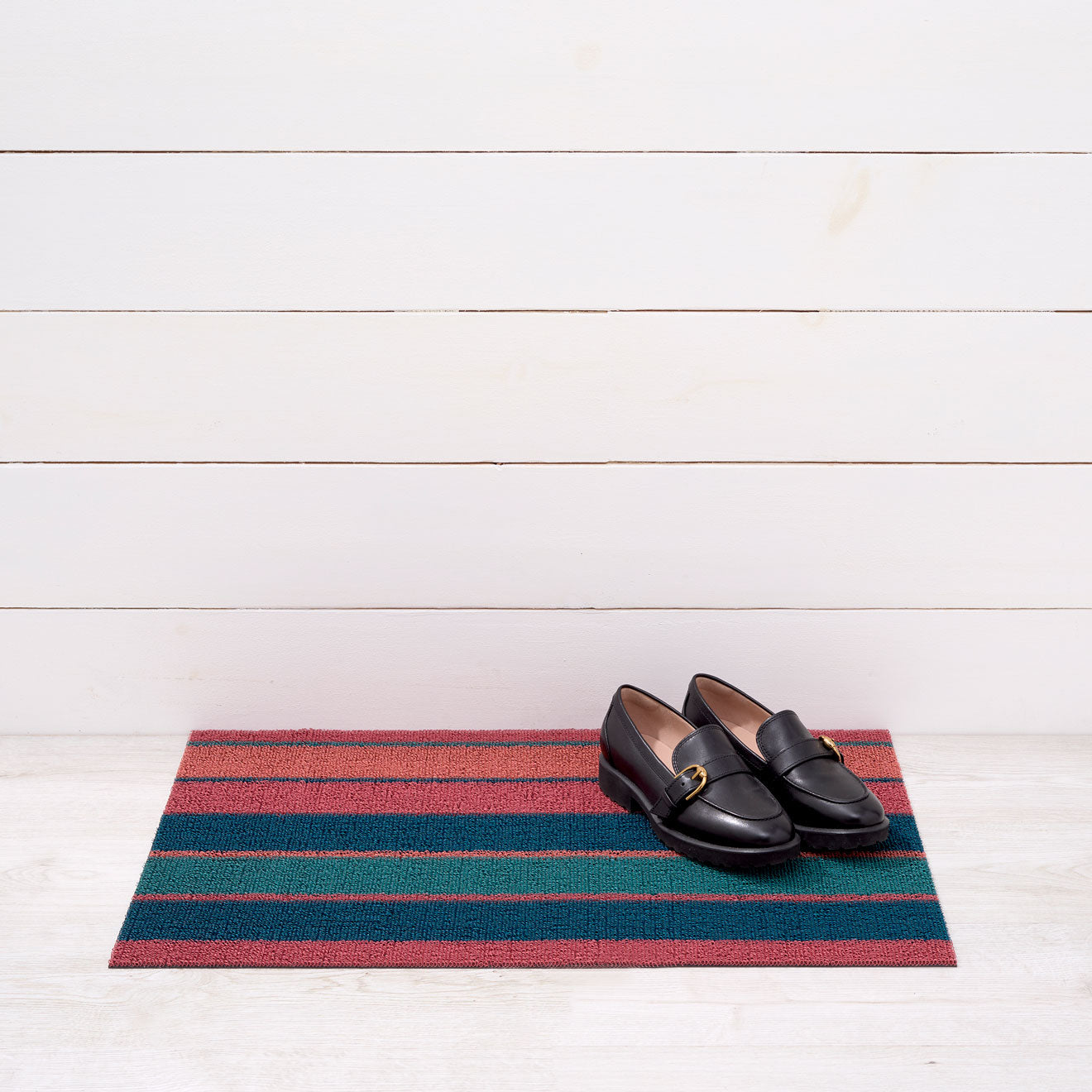 Chilewich striped woven mat with textured terrastrand yarn surface, featuring modern linear design and durable finish.