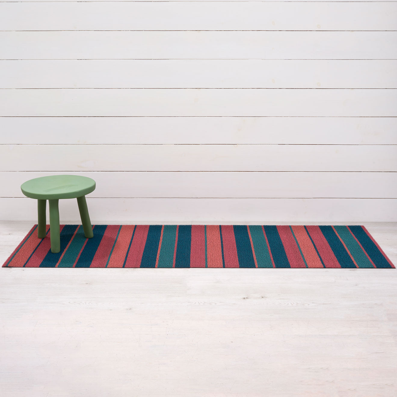 Chilewich striped woven mat with textured terrastrand yarn surface, featuring modern linear design and durable finish.