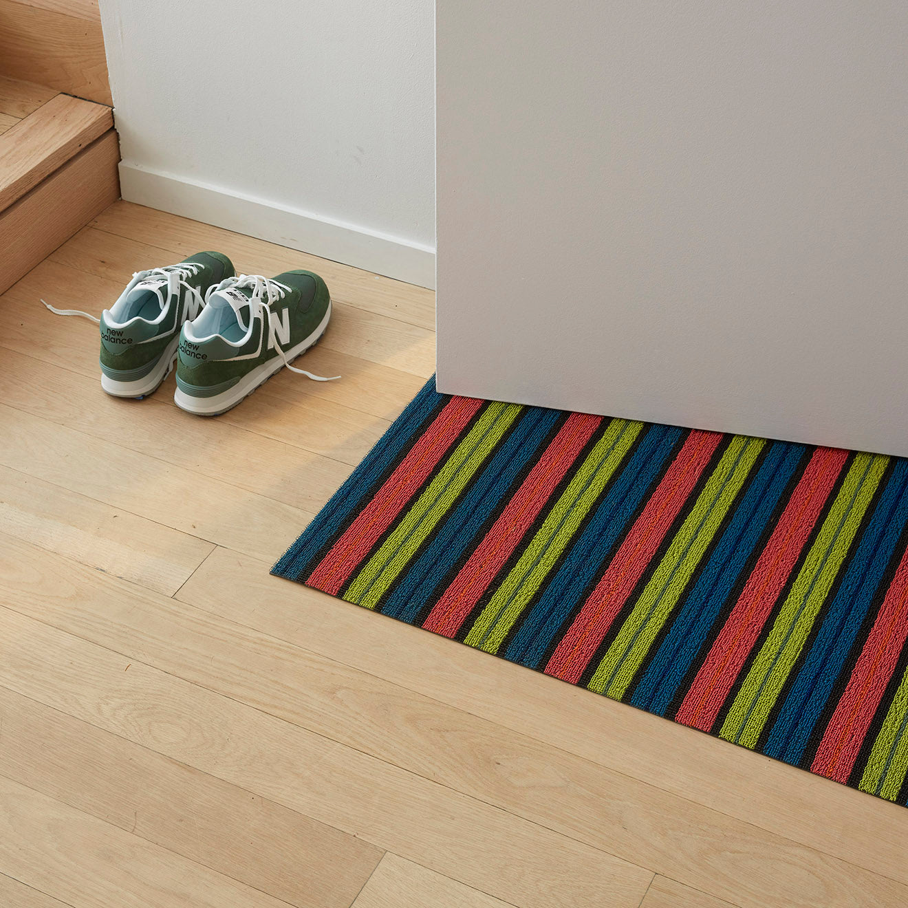 Chilewich striped woven mat with textured terrastrand yarn surface, featuring modern linear design and durable finish.
