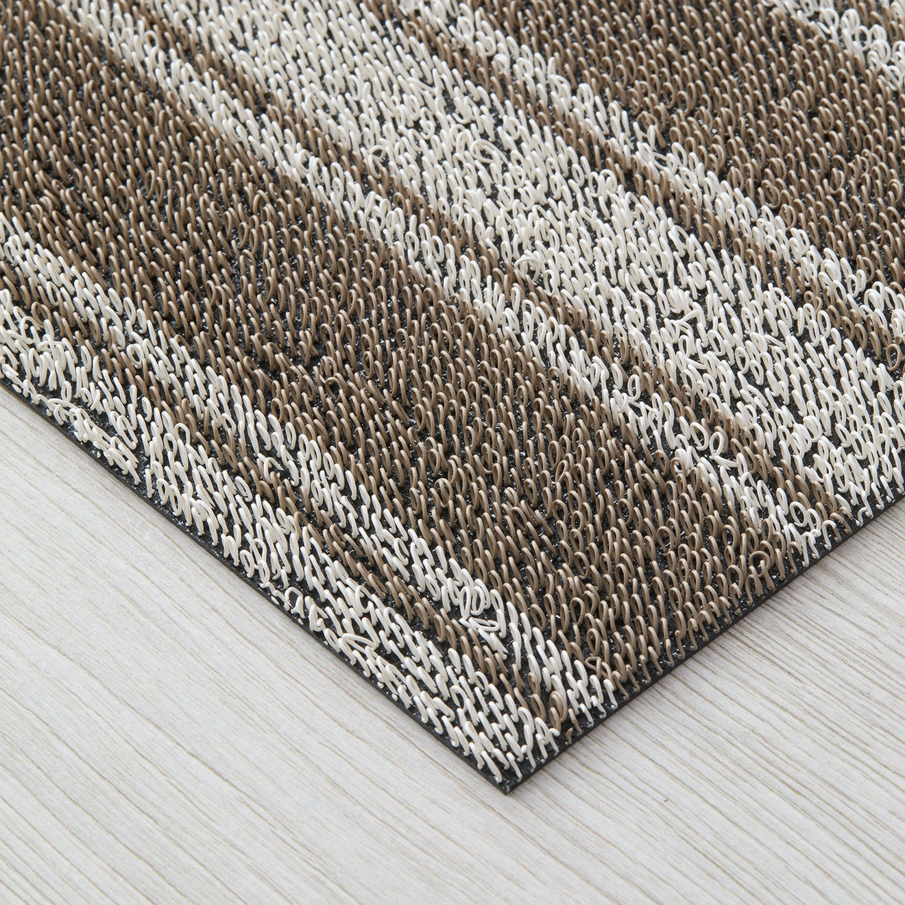 Chilewich striped woven mat with textured terrastrand yarn surface, featuring modern linear design and durable finish.