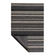 A rectangular rug with a horizontal striped pattern in black, gray, and beige, shown with one bottom corner folded over to reveal the dark backing, on a plain white background.